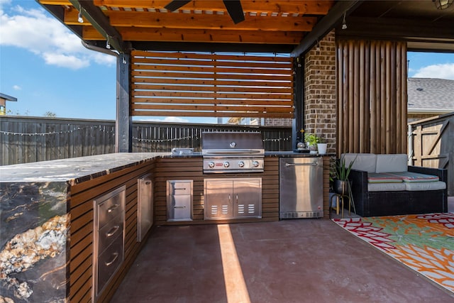 view of patio / terrace with area for grilling, ceiling fan, and an outdoor kitchen