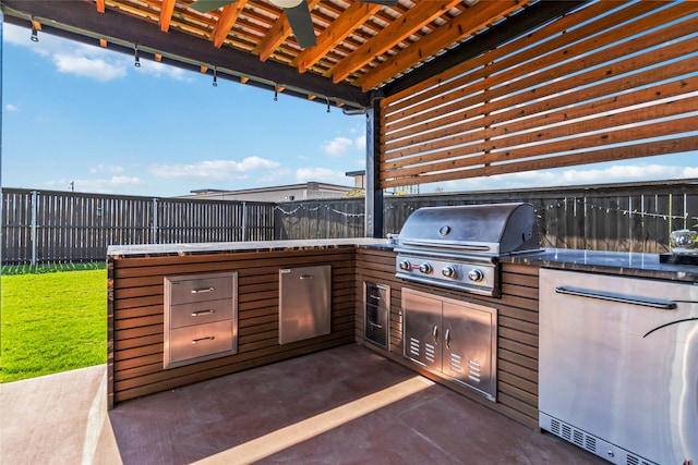 view of patio / terrace featuring ceiling fan, a grill, and exterior kitchen