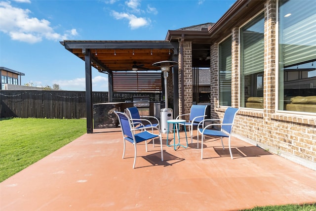 view of patio with grilling area, ceiling fan, and exterior kitchen