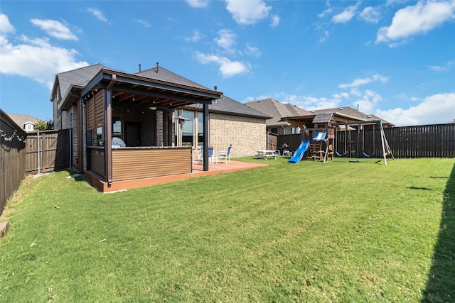 back of property with a playground, a yard, and a patio