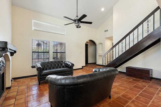 living room featuring dark tile patterned floors, high vaulted ceiling, and ceiling fan