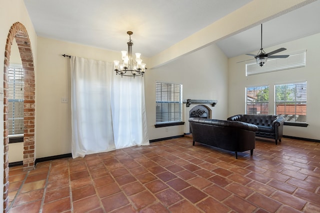 living room featuring ceiling fan with notable chandelier and vaulted ceiling