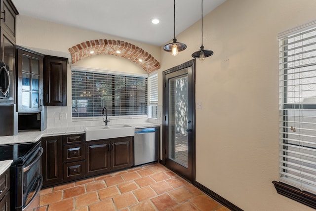 kitchen with sink, stainless steel appliances, dark brown cabinetry, and decorative light fixtures