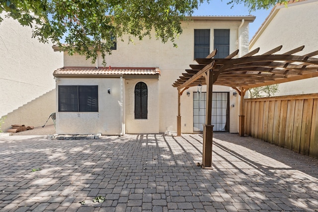 back of property featuring a patio area and a pergola