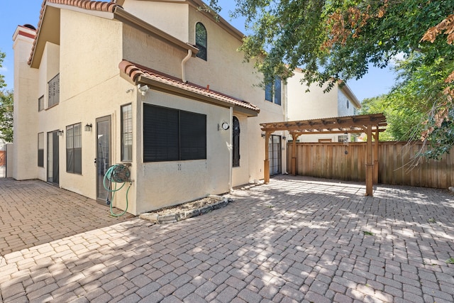 rear view of house with a patio and a pergola