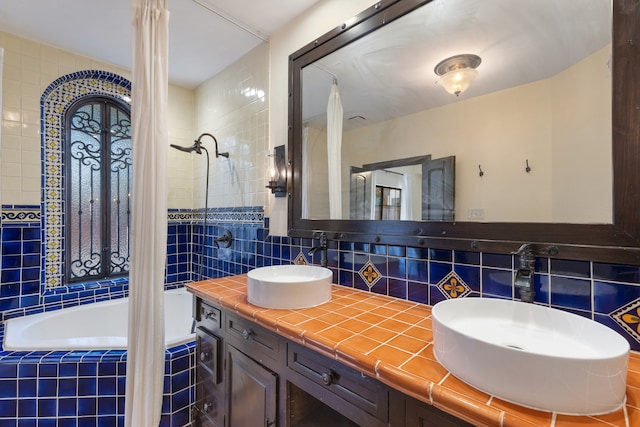 bathroom featuring tiled shower / bath, vanity, backsplash, and tile walls