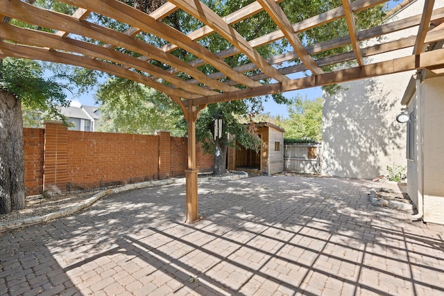 view of patio featuring a pergola and a shed