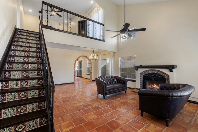 living room featuring a tile fireplace and a towering ceiling