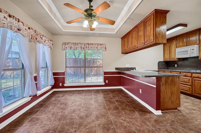 kitchen featuring ceiling fan, ornamental molding, kitchen peninsula, and decorative backsplash