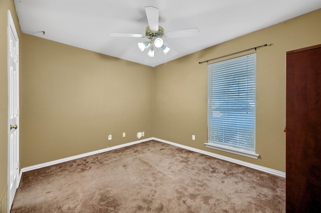 spare room with ceiling fan and carpet