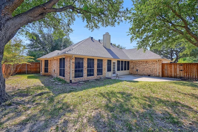 back of property with a yard and a patio area