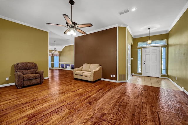 entryway with ceiling fan with notable chandelier, light wood-type flooring, and ornamental molding