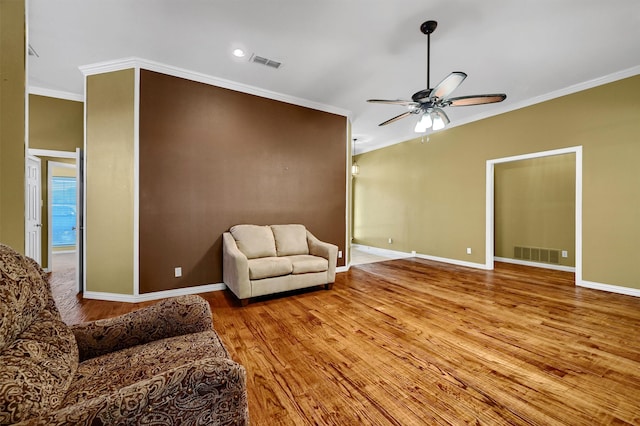 living room with crown molding, light wood-type flooring, and ceiling fan