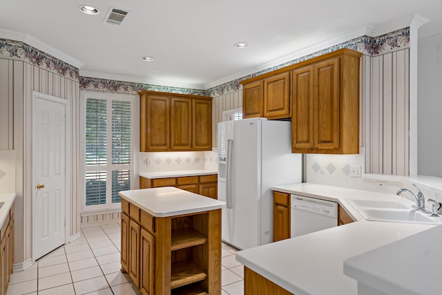 kitchen featuring white appliances, crown molding, a kitchen island, sink, and light tile patterned floors