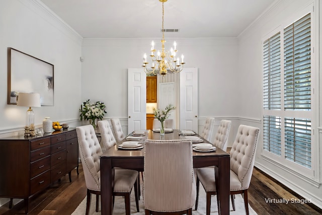 dining area with dark wood-type flooring, ornamental molding, and a notable chandelier