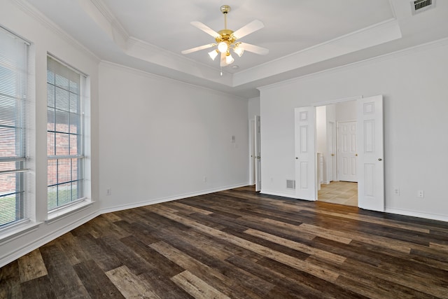 unfurnished bedroom with ceiling fan, a tray ceiling, crown molding, and dark hardwood / wood-style flooring