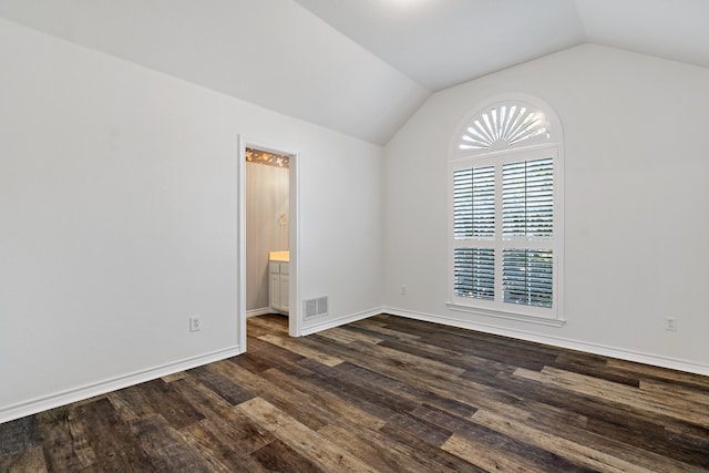 unfurnished room featuring dark hardwood / wood-style floors and vaulted ceiling