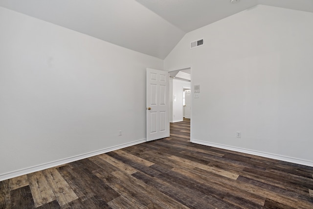 spare room featuring lofted ceiling and dark wood-type flooring