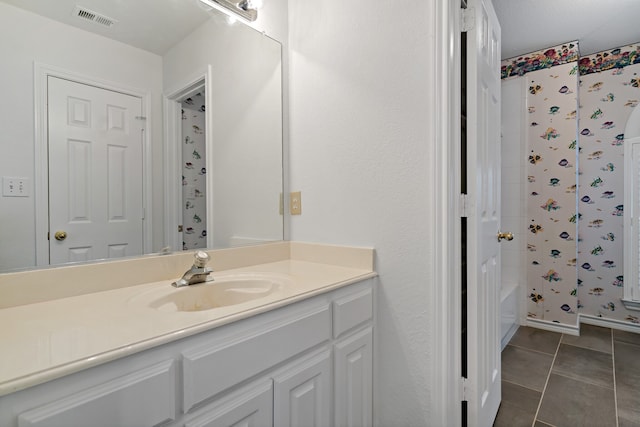 bathroom featuring tile patterned flooring, vanity, and shower / tub combo with curtain