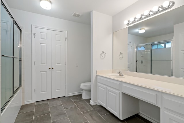 full bathroom featuring vanity, toilet, combined bath / shower with glass door, and tile patterned floors