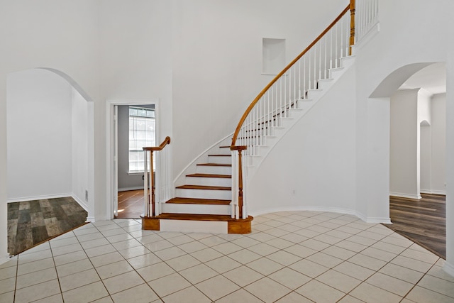 entryway featuring a towering ceiling and light hardwood / wood-style flooring