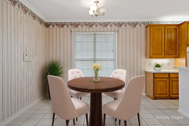 tiled dining room with a chandelier and ornamental molding