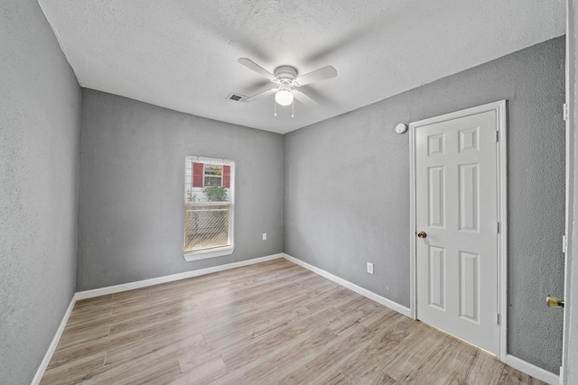 unfurnished room featuring ceiling fan, a textured ceiling, and light hardwood / wood-style flooring