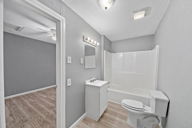 full bathroom featuring ceiling fan, hardwood / wood-style flooring,  shower combination, toilet, and vanity