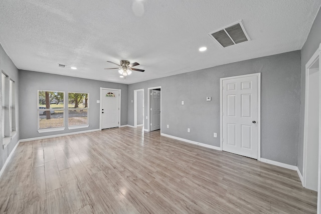 empty room featuring light hardwood / wood-style floors, a textured ceiling, and ceiling fan