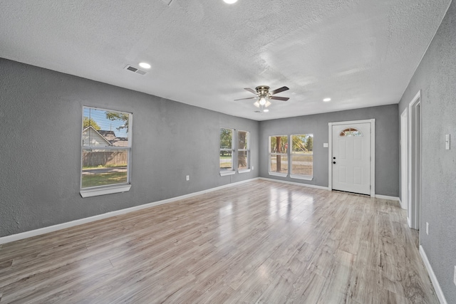 interior space with light hardwood / wood-style flooring, a textured ceiling, and ceiling fan