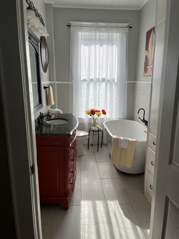 bathroom featuring vanity, crown molding, tile patterned flooring, a bathtub, and toilet