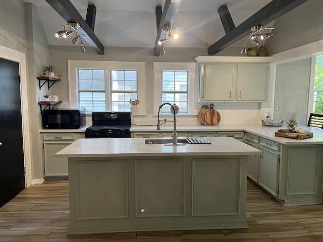 kitchen with vaulted ceiling with beams, sink, a kitchen island, light hardwood / wood-style flooring, and black appliances