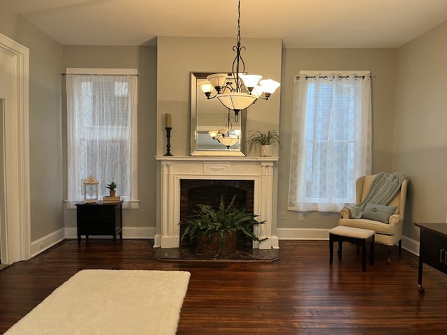 sitting room featuring a chandelier and dark hardwood / wood-style flooring