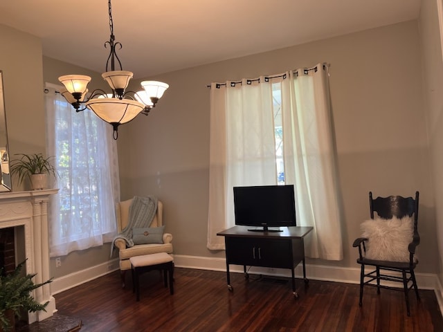 sitting room featuring a notable chandelier, dark wood-type flooring, and a wealth of natural light