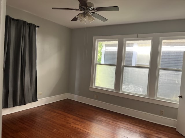 spare room featuring ceiling fan and dark wood-type flooring