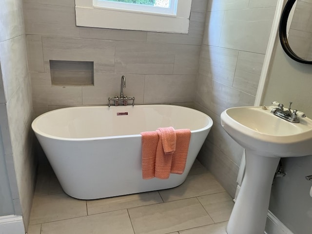 bathroom featuring a bathing tub, tile patterned flooring, and tile walls