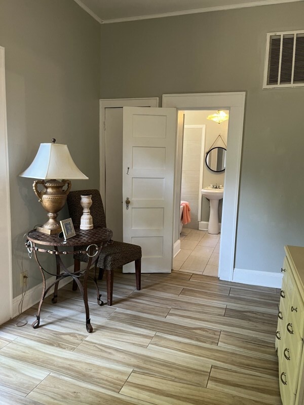 sitting room with crown molding and sink