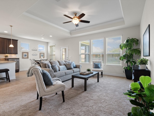 living room featuring a tray ceiling, ceiling fan, and light colored carpet