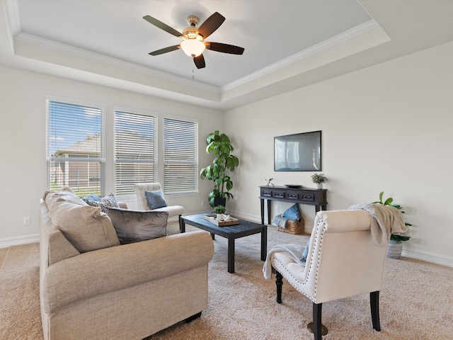 carpeted living room featuring a raised ceiling, ceiling fan, and crown molding