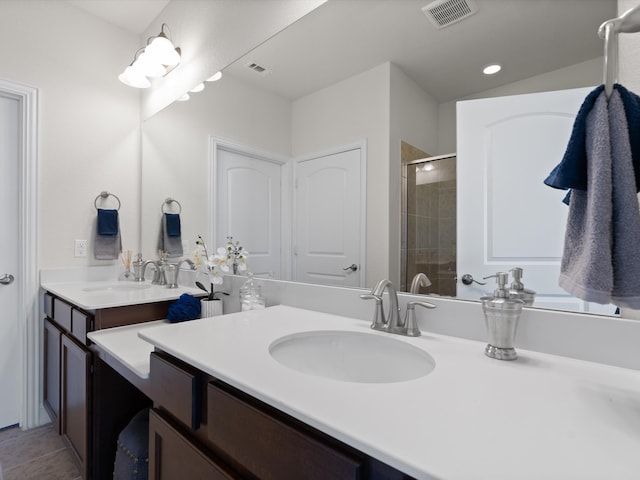 bathroom featuring tile patterned floors, vanity, and a shower with shower door