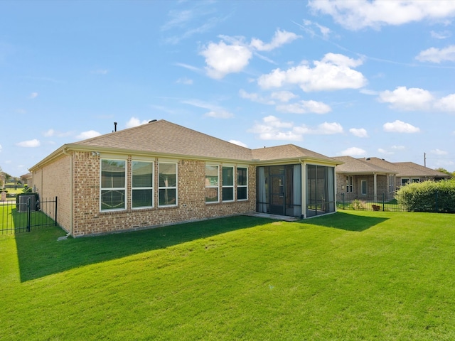 rear view of property with a yard and a sunroom