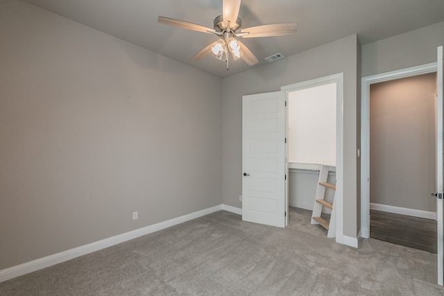 unfurnished bedroom with light carpet, ceiling fan, and a closet