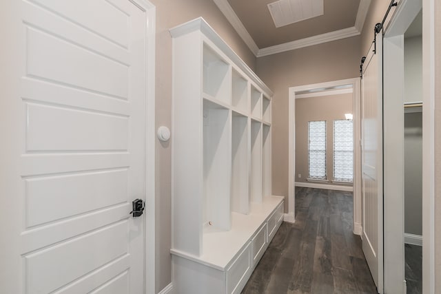 mudroom with ornamental molding, dark hardwood / wood-style floors, and a barn door