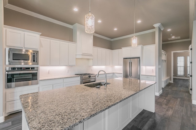 kitchen with light stone counters, white cabinets, sink, high end appliances, and dark wood-type flooring