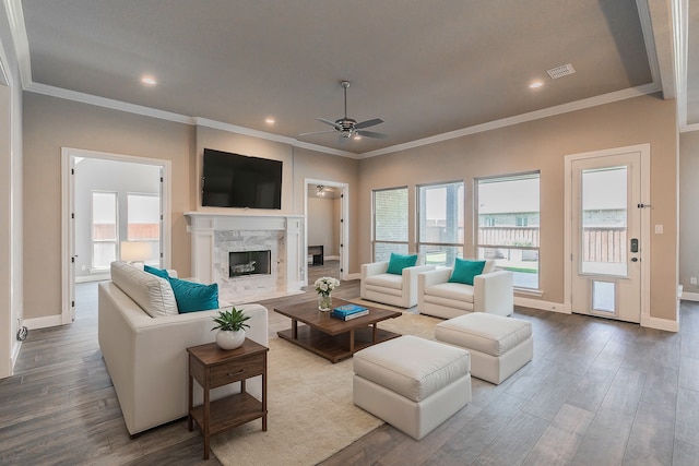 living room featuring a high end fireplace, ceiling fan, and light hardwood / wood-style floors