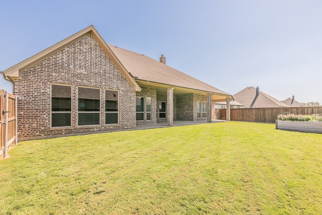 back of property featuring a yard and a patio