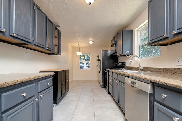 kitchen featuring light tile patterned floors, hanging light fixtures, stainless steel appliances, and a textured ceiling