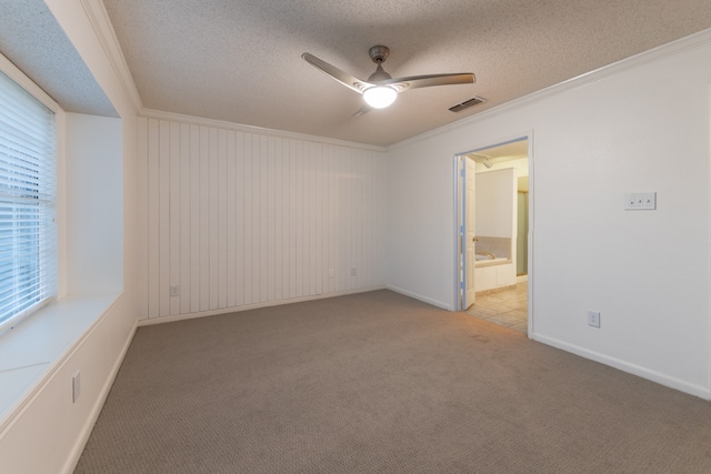 empty room with ceiling fan, light colored carpet, a textured ceiling, and ornamental molding