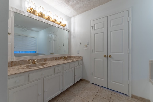 bathroom featuring tile patterned flooring, vanity, and a textured ceiling