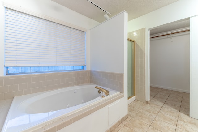 bathroom with tile patterned floors, separate shower and tub, and a textured ceiling